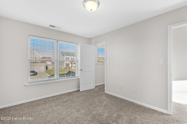 carpeted spare room with visible vents and baseboards