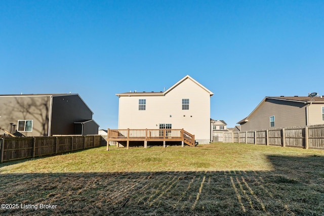 back of house with a fenced backyard, a yard, and a deck