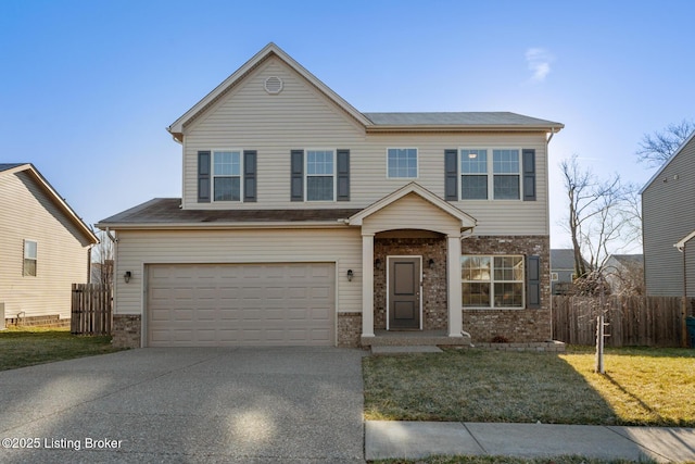 traditional-style home with concrete driveway, an attached garage, fence, a front lawn, and brick siding