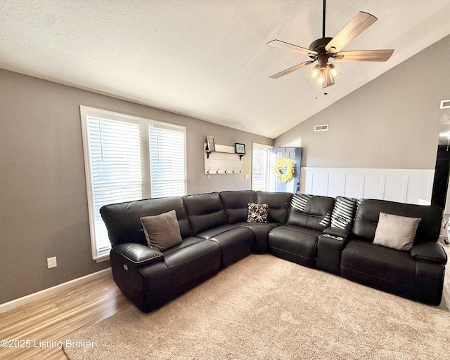 living room featuring lofted ceiling, a wealth of natural light, and a textured ceiling