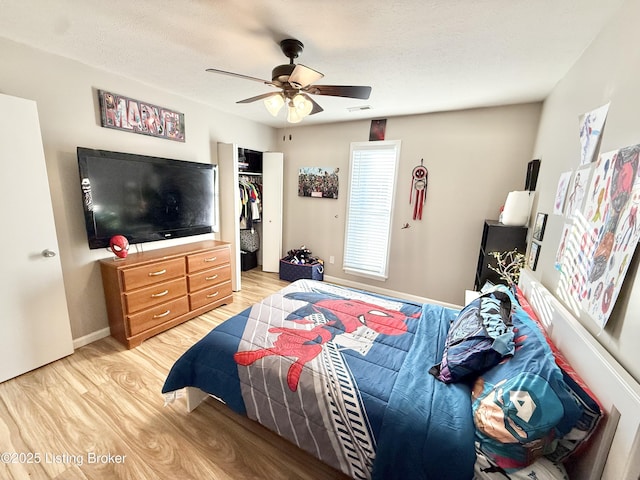 bedroom with ceiling fan, light hardwood / wood-style flooring, and a textured ceiling