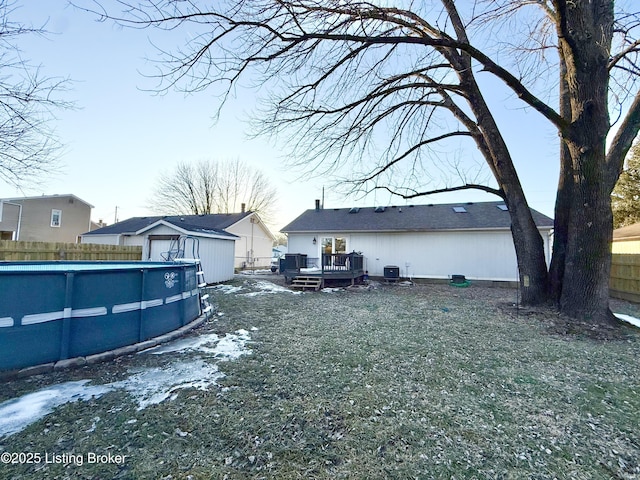 exterior space with a pool side deck, cooling unit, and a storage shed