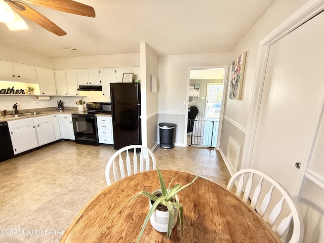 kitchen with sink, white cabinetry, light stone counters, ceiling fan, and black appliances