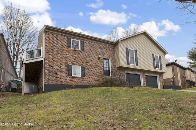 raised ranch featuring a garage, a front yard, and cooling unit