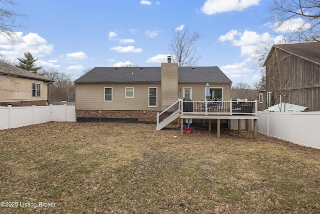 back of house featuring a deck and a lawn