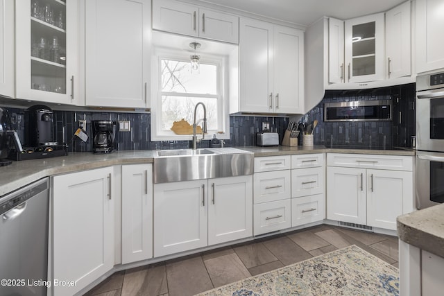 kitchen featuring tasteful backsplash, sink, stainless steel appliances, and white cabinets