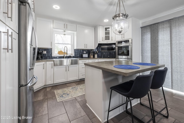 kitchen with white cabinetry, sink, and a kitchen island