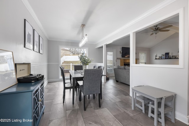 dining space with crown molding, vaulted ceiling, and ceiling fan