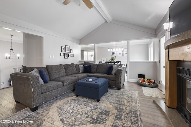 living room featuring hardwood / wood-style flooring, vaulted ceiling with beams, and ceiling fan with notable chandelier