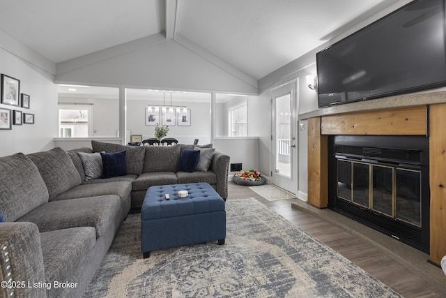 living room with lofted ceiling with beams, wood-type flooring, and a notable chandelier