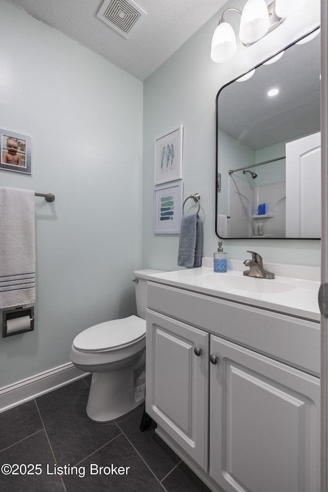 bathroom with walk in shower, tile patterned floors, toilet, a textured ceiling, and vanity