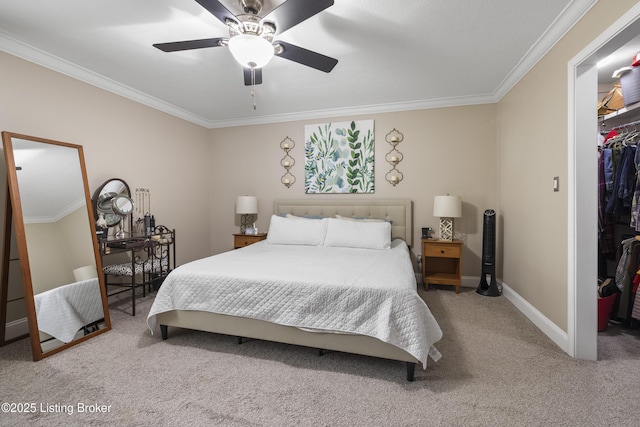 carpeted bedroom with crown molding, a spacious closet, ceiling fan, and a closet