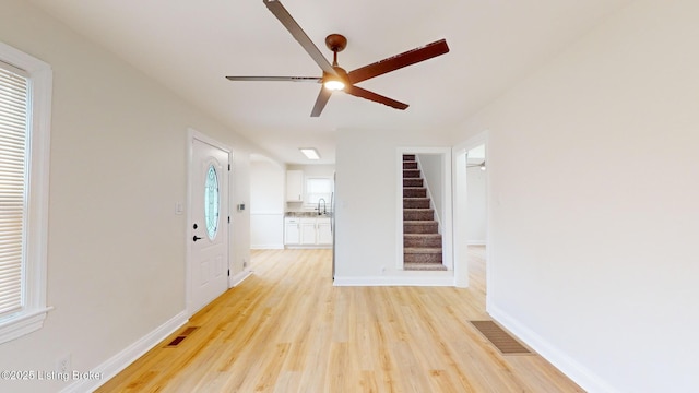 interior space with sink, ceiling fan, and light hardwood / wood-style flooring