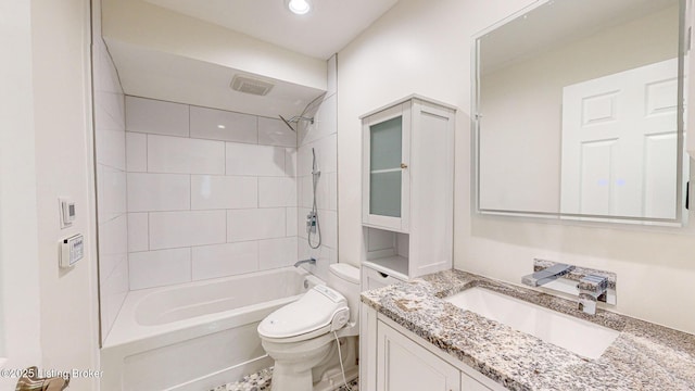 full bathroom featuring tiled shower / bath combo, vanity, and toilet