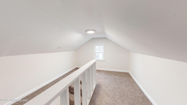 hallway with lofted ceiling and light carpet