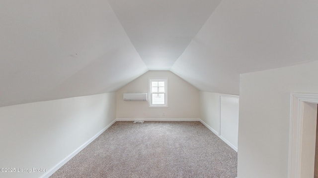 additional living space featuring lofted ceiling, a wall mounted air conditioner, and light carpet