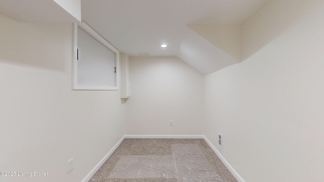 interior space with light carpet and lofted ceiling