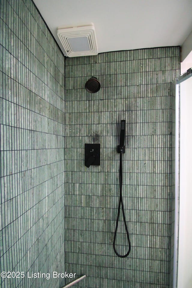 interior details featuring tiled shower