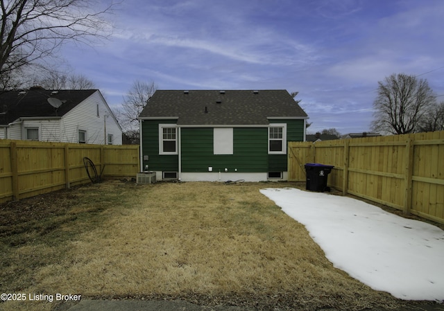 rear view of property with central AC and a yard