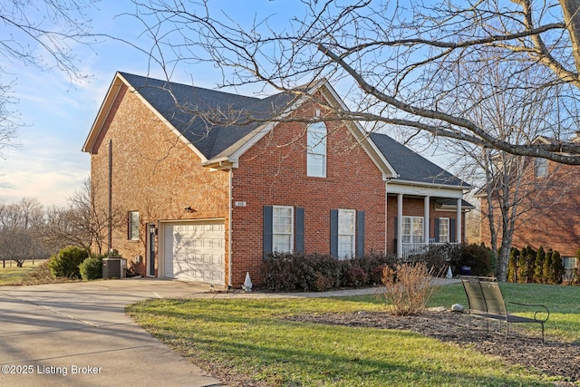 view of front of property with a garage, central AC unit, and a front yard