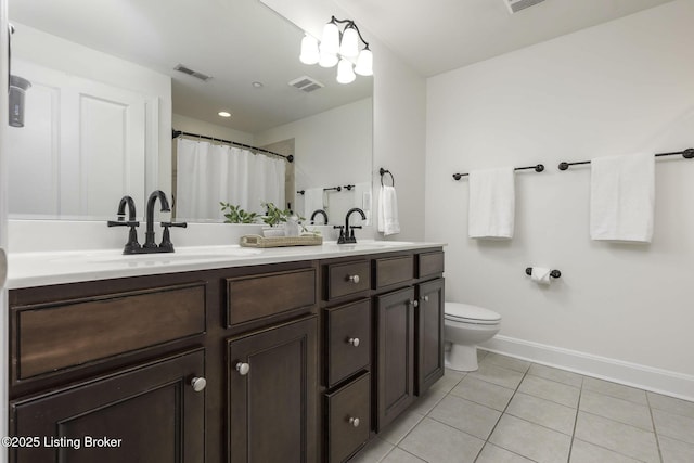 bathroom featuring tile patterned floors, visible vents, and a sink