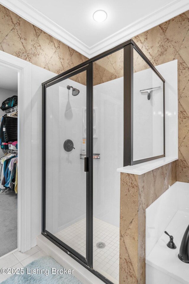 bathroom featuring ornamental molding, tile patterned flooring, a spacious closet, a shower stall, and a bath