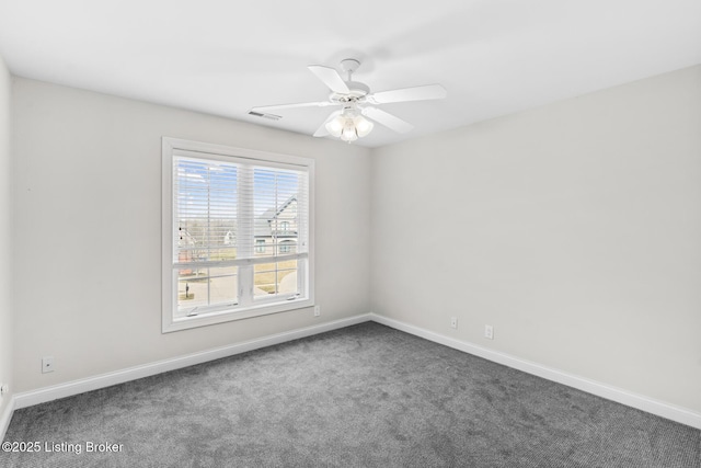 carpeted spare room featuring ceiling fan, visible vents, and baseboards