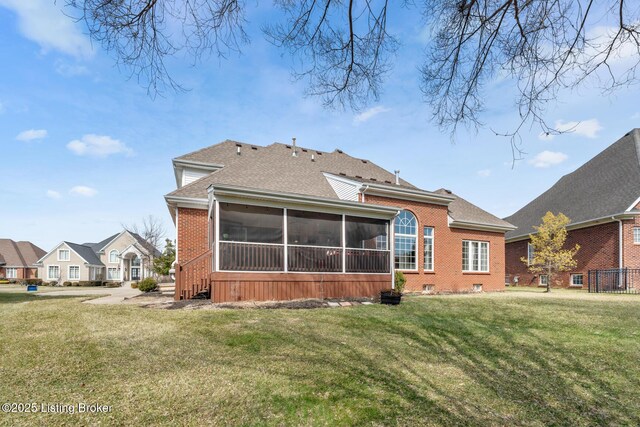 rear view of house with crawl space, a sunroom, a lawn, and brick siding