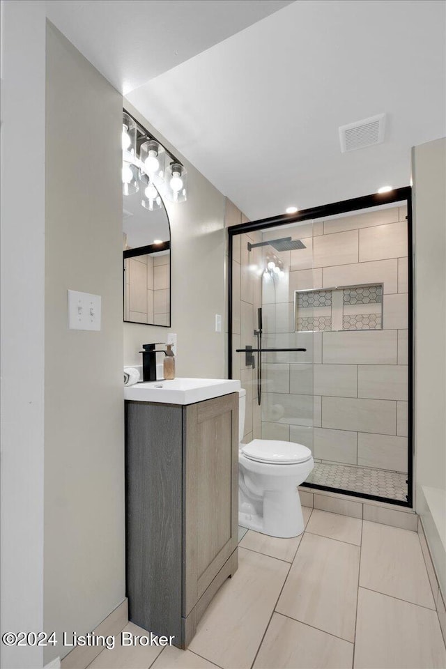 bathroom featuring vanity, toilet, an enclosed shower, and tile patterned flooring