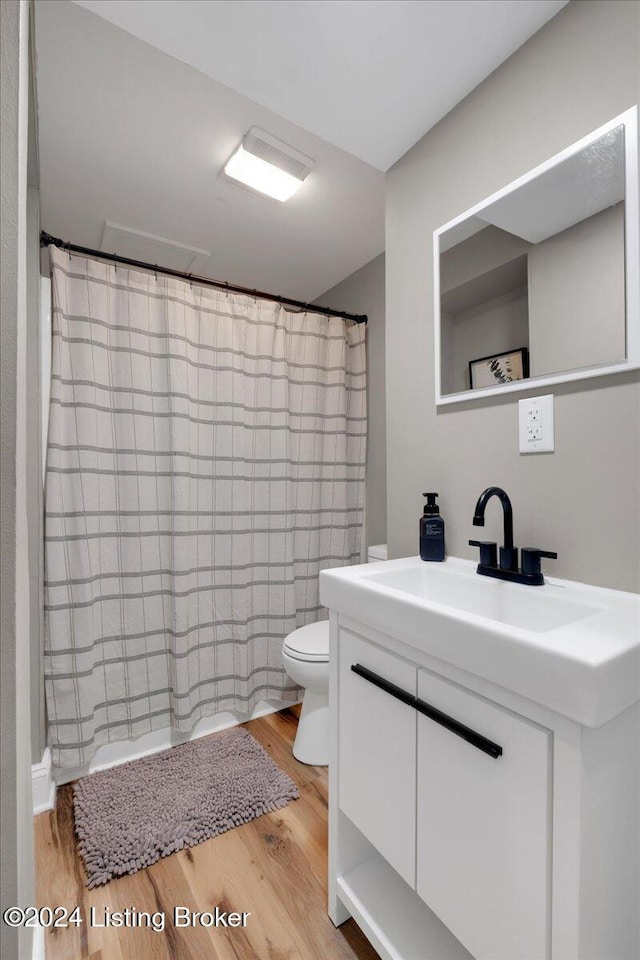 bathroom featuring vanity, hardwood / wood-style floors, toilet, and a shower with shower curtain