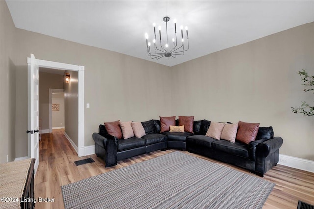 living room featuring an inviting chandelier and light hardwood / wood-style flooring