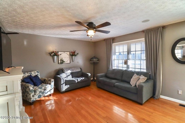 living room with wood-type flooring, a textured ceiling, and ceiling fan