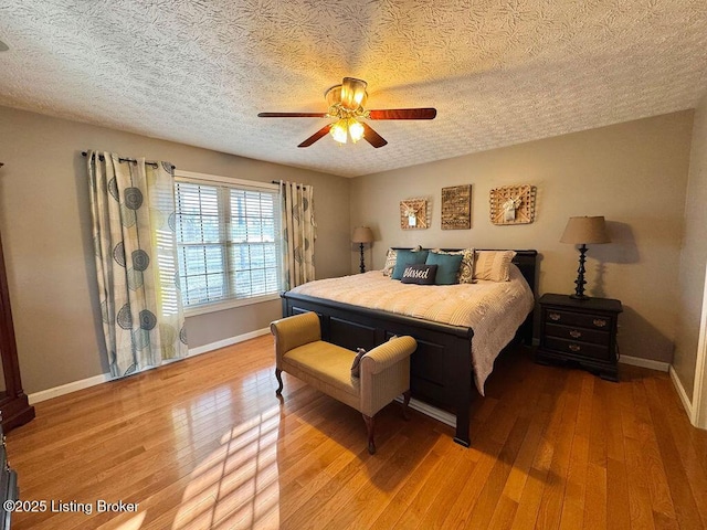 bedroom featuring hardwood / wood-style floors, a textured ceiling, and ceiling fan