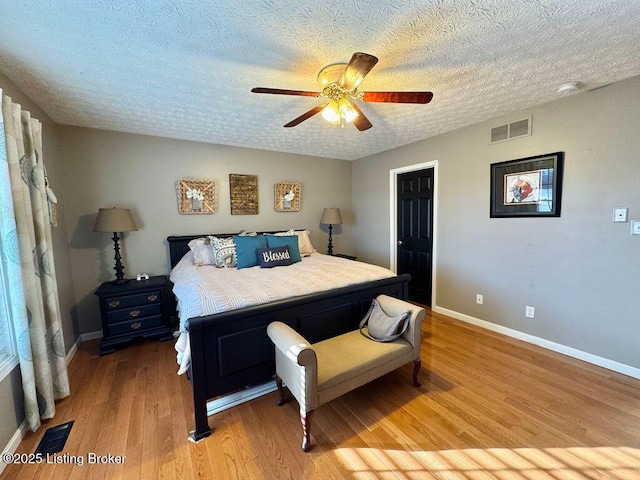 bedroom featuring ceiling fan, a textured ceiling, and light wood-type flooring