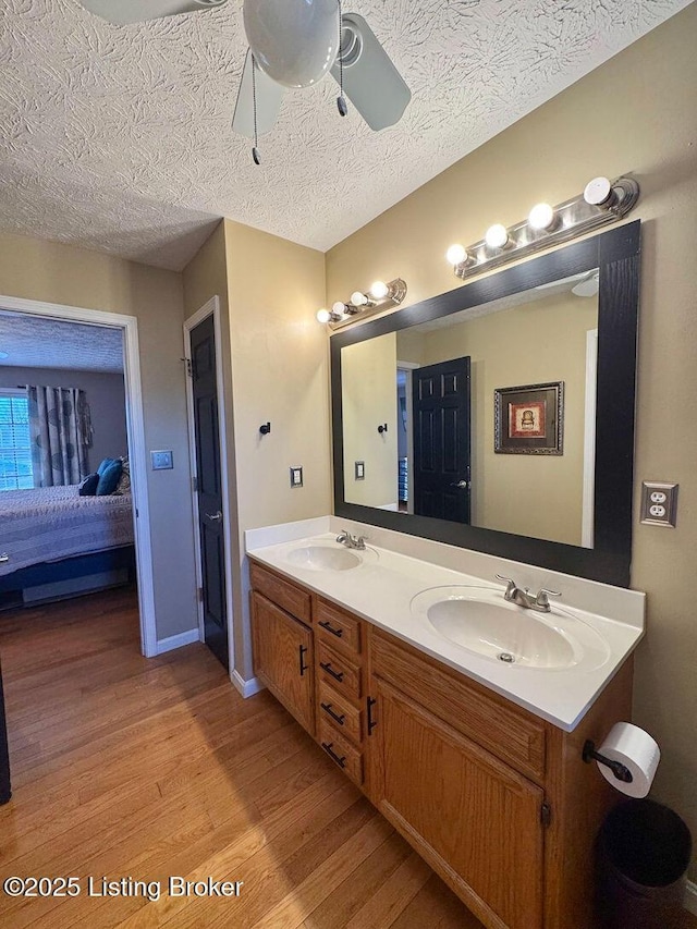 bathroom with hardwood / wood-style flooring, vanity, a textured ceiling, and ceiling fan