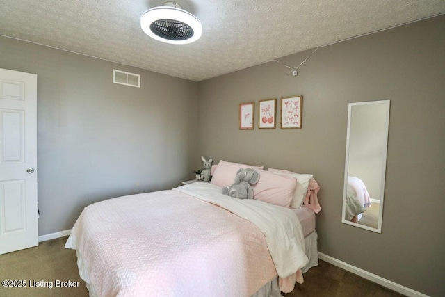 bedroom with dark colored carpet and a textured ceiling