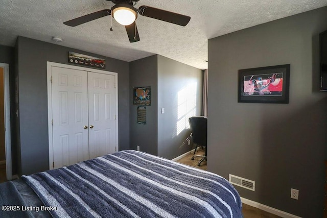 bedroom with a textured ceiling, ceiling fan, and a closet