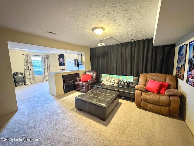 carpeted home theater room featuring a textured ceiling