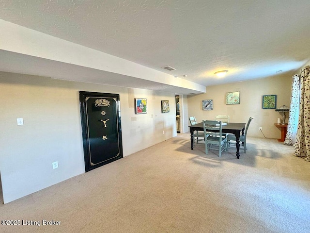 carpeted dining room featuring a textured ceiling