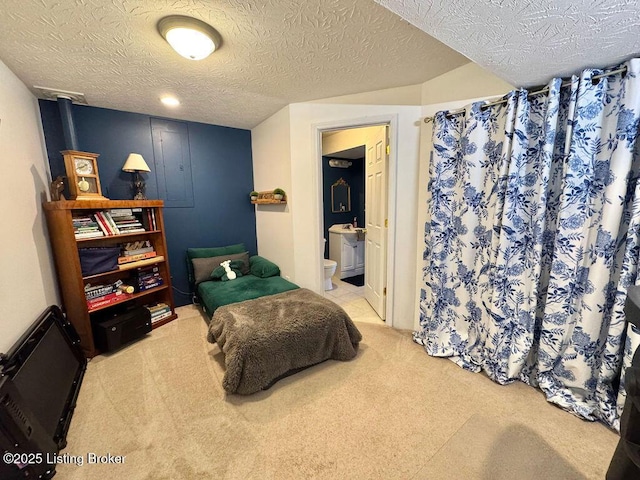 bedroom with carpet flooring, connected bathroom, and a textured ceiling