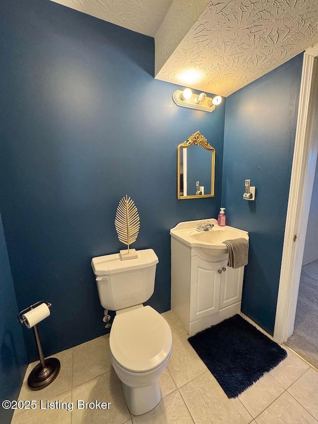 bathroom with vanity, a textured ceiling, tile patterned floors, and toilet