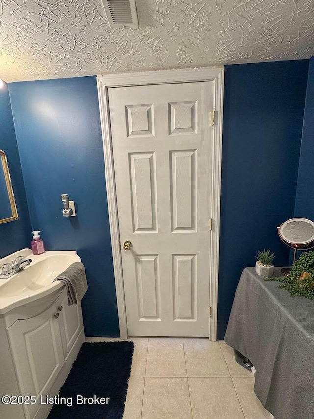 bathroom featuring vanity, tile patterned flooring, and a textured ceiling