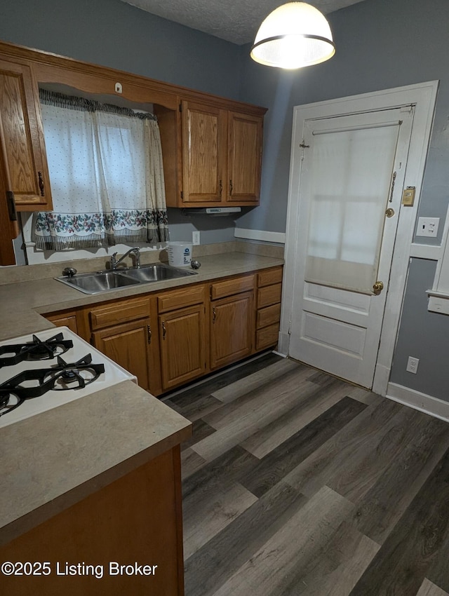 kitchen featuring sink, a textured ceiling, and dark hardwood / wood-style floors