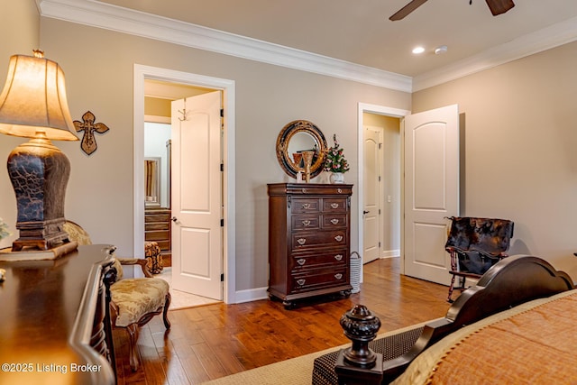 bedroom featuring hardwood / wood-style floors, crown molding, and ceiling fan