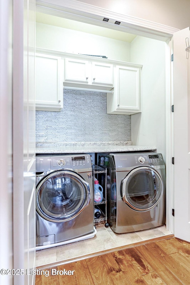 laundry room with light hardwood / wood-style flooring and washer and dryer