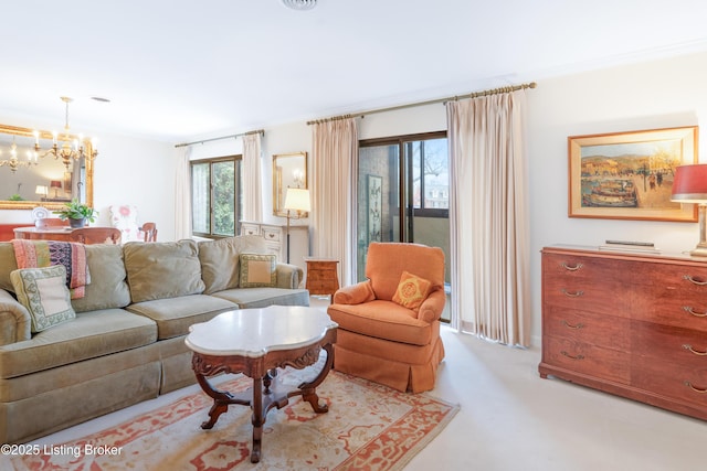 carpeted living room with crown molding and a chandelier