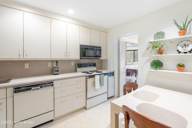 kitchen featuring white cabinetry, sink, white appliances, and tasteful backsplash