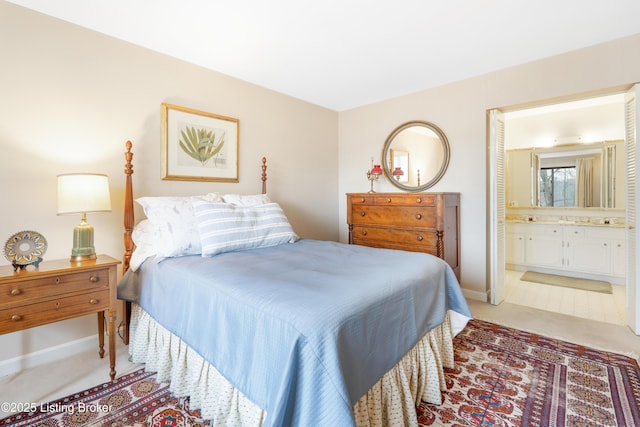 bedroom featuring ensuite bath and light colored carpet