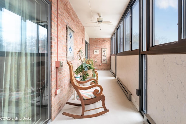 hall with a healthy amount of sunlight, brick wall, and a baseboard heating unit