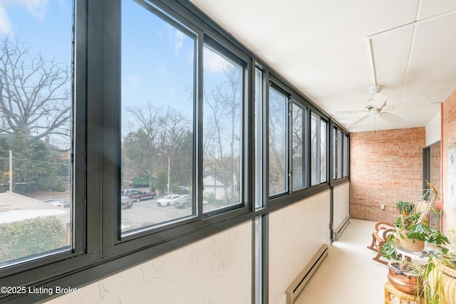 sunroom / solarium featuring plenty of natural light, ceiling fan, and baseboard heating